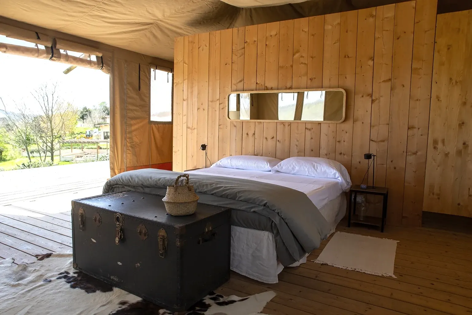 Interno di un lodge con letto matrimoniale e pareti in legno